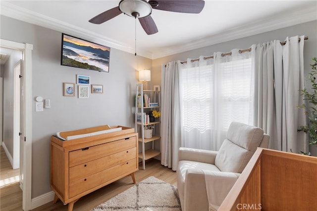 sitting room with ceiling fan, crown molding, and light hardwood / wood-style flooring