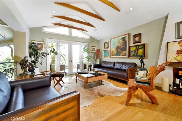 living room with light wood-type flooring, french doors, and lofted ceiling with beams