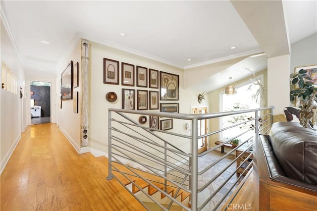 corridor with light wood-type flooring and crown molding