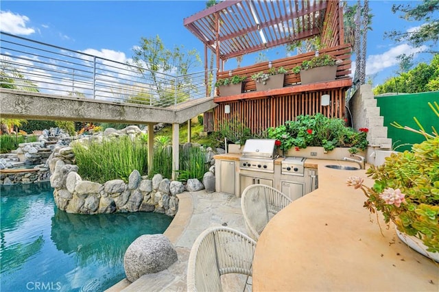 view of patio with exterior kitchen, sink, area for grilling, and a pergola