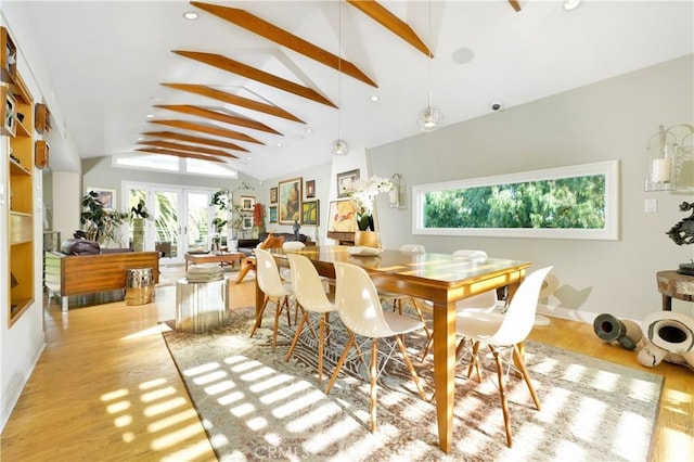 dining area featuring vaulted ceiling with beams, french doors, and light hardwood / wood-style floors