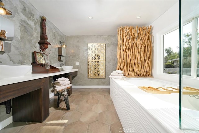 bathroom with a tub and vanity