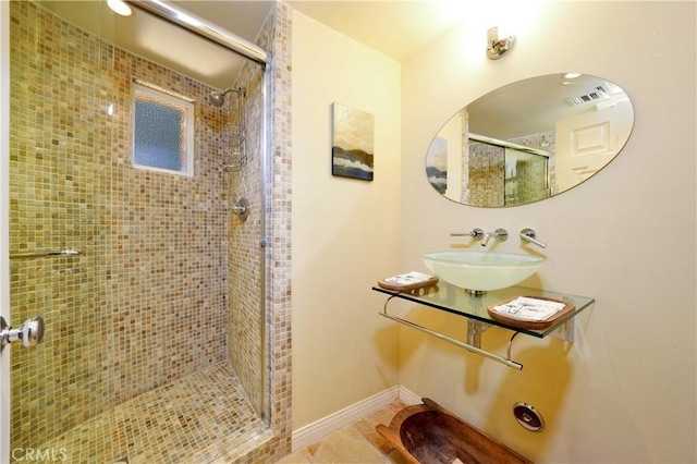 bathroom with tile patterned flooring, sink, and a shower with shower door