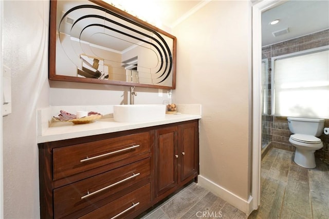 bathroom with hardwood / wood-style flooring, crown molding, vanity, and toilet