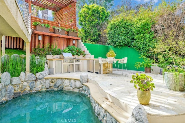 view of swimming pool with a pergola, a patio area, area for grilling, and an outdoor kitchen