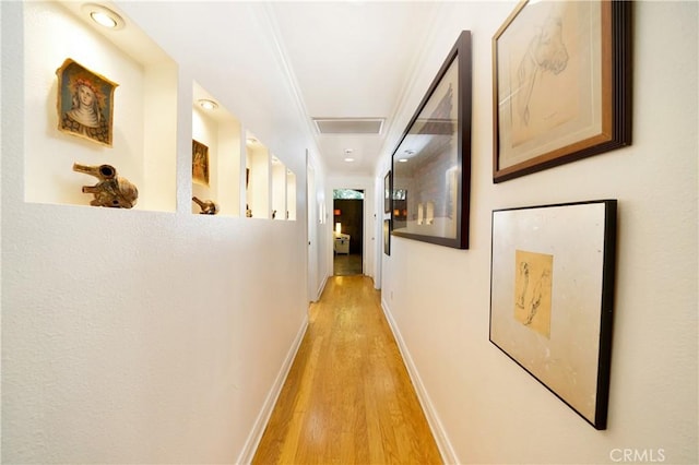 hallway featuring light hardwood / wood-style floors and crown molding