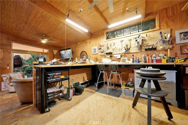 bar with light hardwood / wood-style floors, wood ceiling, wooden walls, and a workshop area