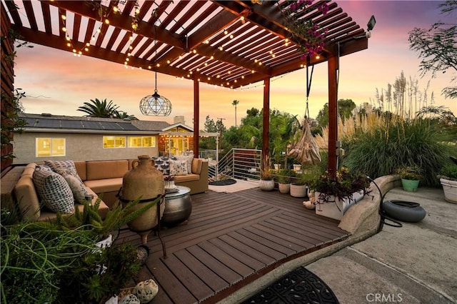 patio terrace at dusk featuring an outdoor hangout area, a pergola, and a deck