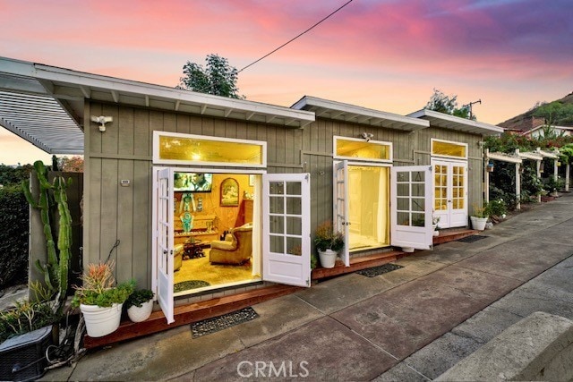 outdoor structure at dusk featuring french doors