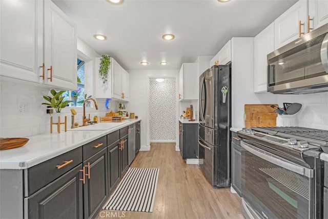 kitchen featuring appliances with stainless steel finishes, white cabinets, and sink