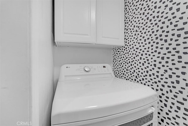 clothes washing area with cabinets and washer / clothes dryer