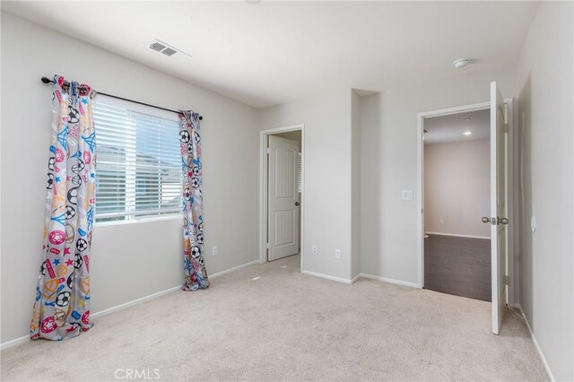 unfurnished bedroom with light colored carpet