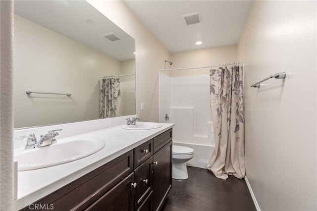 full bathroom with hardwood / wood-style flooring, vanity, shower / tub combo with curtain, and toilet