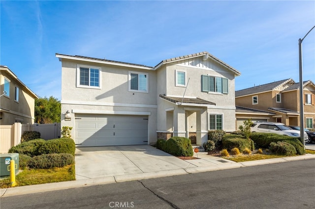 traditional home with driveway, an attached garage, fence, and stucco siding