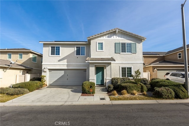 traditional-style home with a garage, driveway, and stucco siding