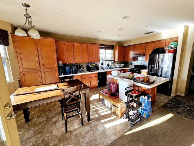 kitchen with decorative light fixtures, black appliances, and a kitchen island