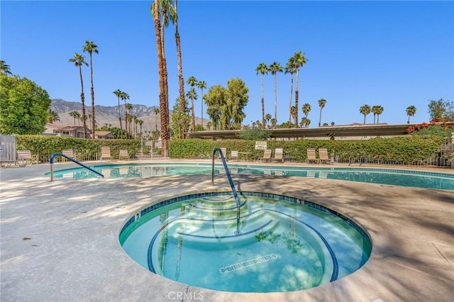 view of swimming pool featuring a mountain view and a community hot tub