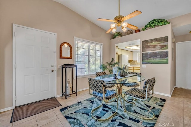 tiled dining area with ceiling fan and vaulted ceiling