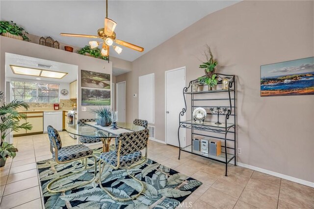 tiled dining space with ceiling fan and vaulted ceiling