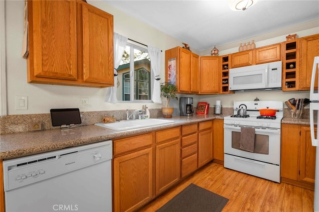 kitchen with sink, white appliances, and light hardwood / wood-style flooring