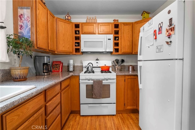 kitchen featuring light hardwood / wood-style flooring and white appliances