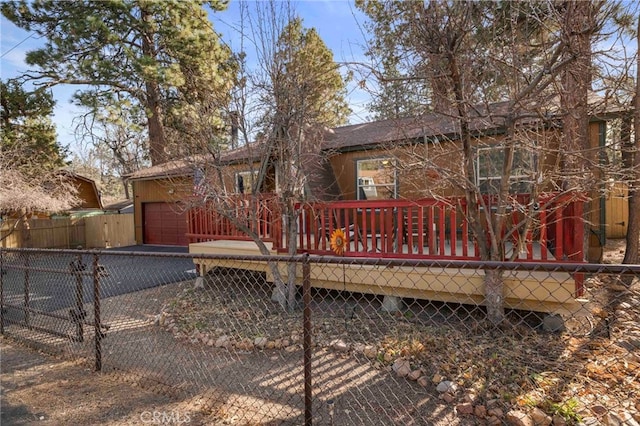 rear view of property with a garage and a deck