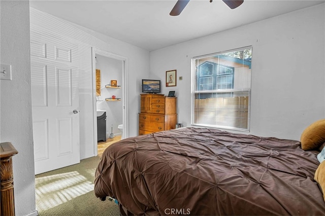 bedroom with ceiling fan, carpet floors, and ensuite bath