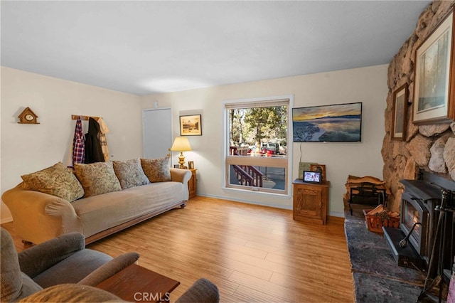 living room featuring a wood stove and light hardwood / wood-style floors