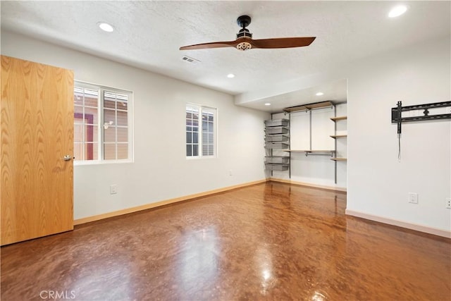 unfurnished living room with ceiling fan, a textured ceiling, and concrete flooring