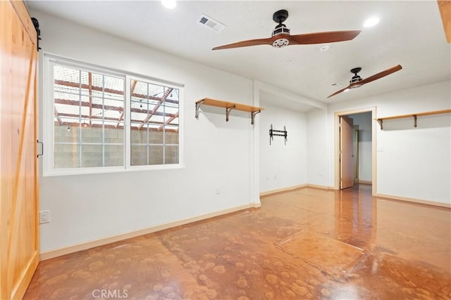 empty room with ceiling fan and a barn door