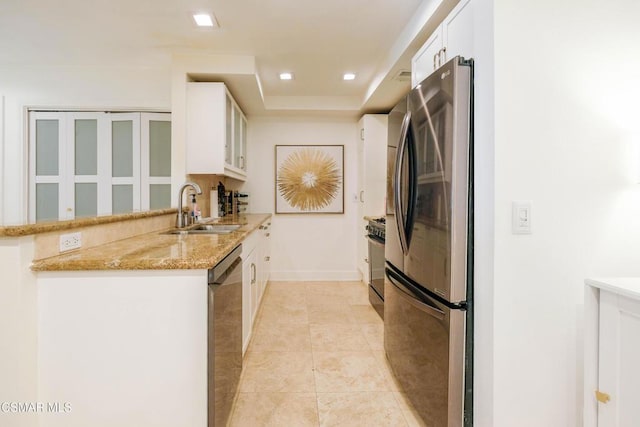 kitchen with white cabinets, stainless steel appliances, sink, light tile patterned flooring, and light stone counters