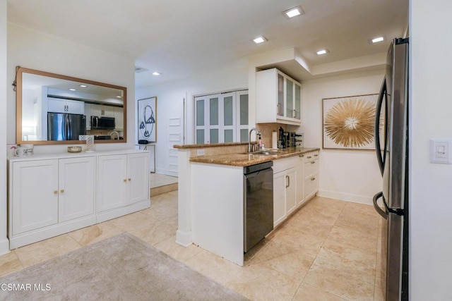 kitchen featuring kitchen peninsula, appliances with stainless steel finishes, white cabinets, light stone counters, and sink