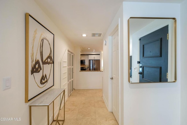 hall featuring light tile patterned floors