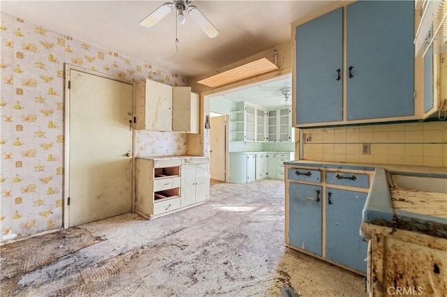 kitchen featuring ceiling fan, sink, backsplash, and blue cabinets