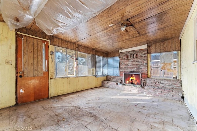 unfurnished sunroom with a brick fireplace, wood ceiling, and lofted ceiling