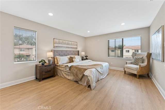 bedroom with multiple windows and light hardwood / wood-style floors