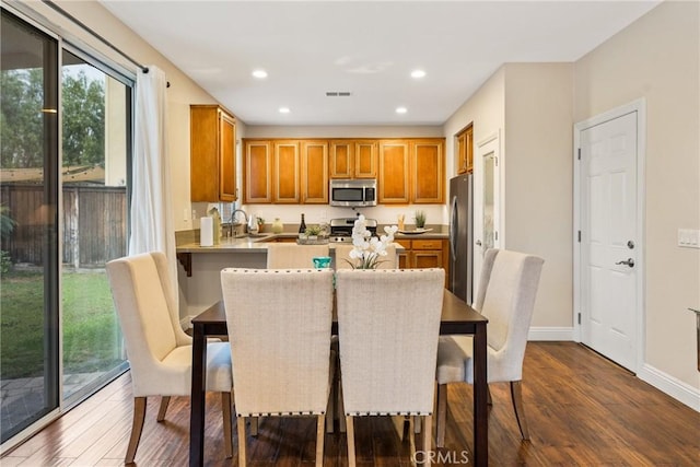 dining space with dark hardwood / wood-style floors and sink