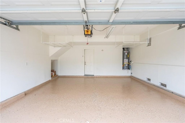 garage with water heater and a garage door opener