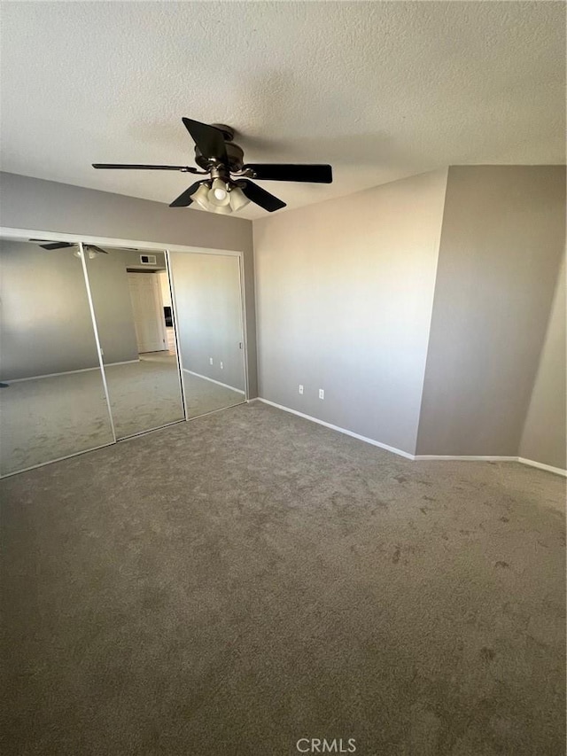 unfurnished bedroom featuring ceiling fan, carpet floors, a closet, and a textured ceiling