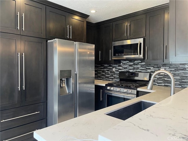 kitchen featuring stainless steel appliances, light stone countertops, and decorative backsplash