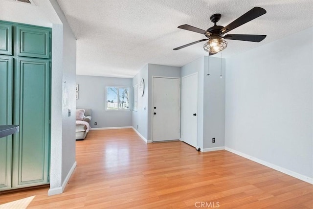 interior space featuring light wood-type flooring, ceiling fan, and a textured ceiling