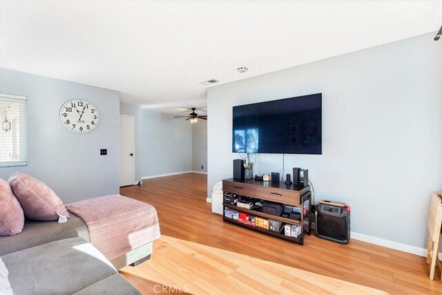 living room with ceiling fan and wood-type flooring