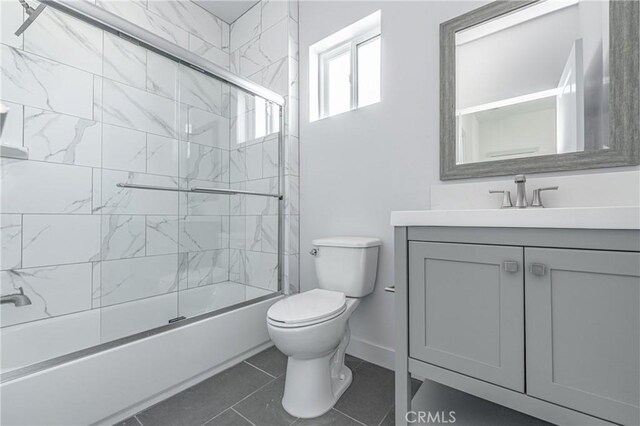 full bathroom featuring toilet, vanity, tile patterned flooring, and shower / bath combination with glass door