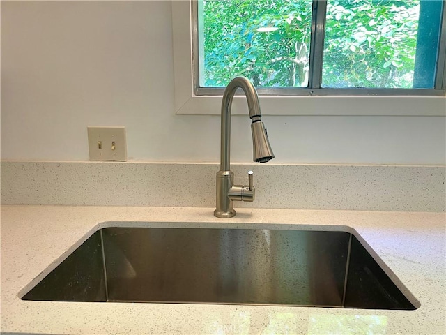 details featuring light stone counters and sink