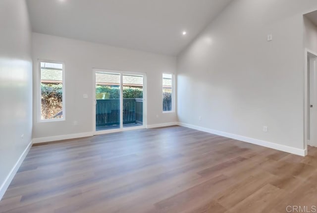 unfurnished room with high vaulted ceiling and wood-type flooring