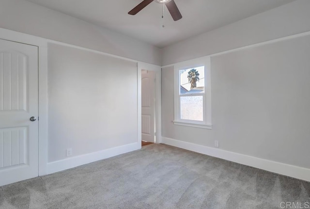 carpeted spare room featuring ceiling fan