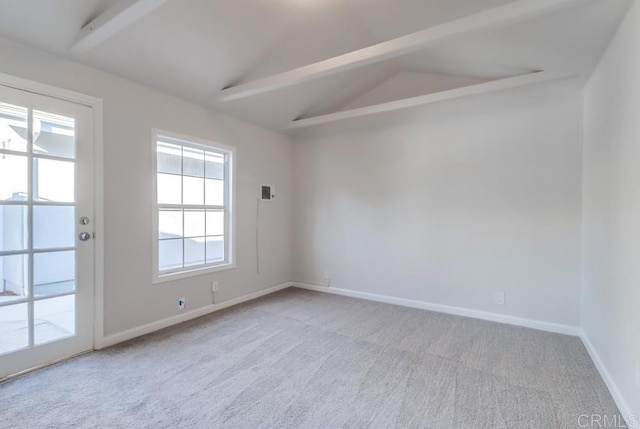 spare room featuring light carpet and lofted ceiling with beams