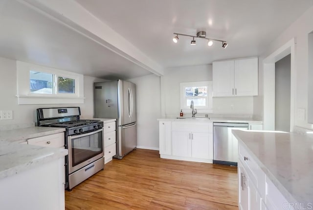 kitchen with white cabinets, appliances with stainless steel finishes, and plenty of natural light