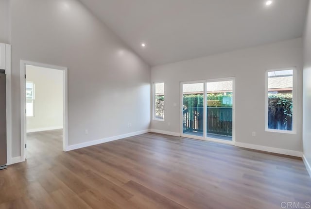 spare room with high vaulted ceiling and hardwood / wood-style floors