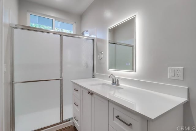 bathroom with a shower with shower door and vanity